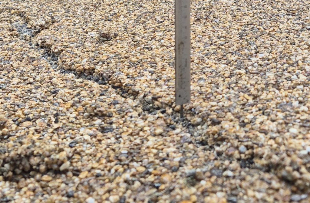 Close-up image of a crack in a resin driveway, highlighting the need for regular maintenance and prompt repairs.