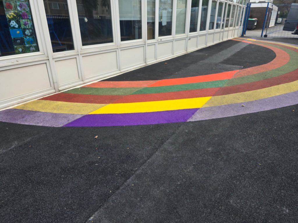 Rainbow coloured wet pour repair completed at a school playground in Hayes